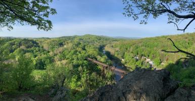 View of the Rondout Creek, surrounding forested slopes, and Rosendale trestle in Spring. By L Heady
