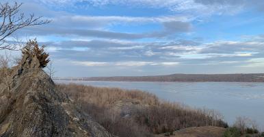 view of Hudson River from forested ledge in winter