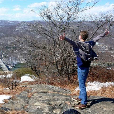 A hiker looks out over the Hudson River from the Anthony's Nose lookout - by L Heady