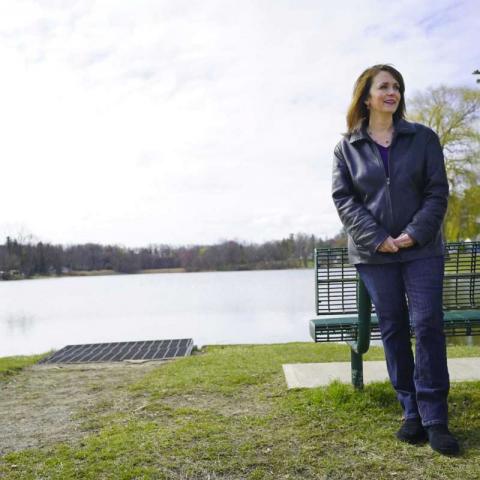 Town Councilwoman stands on the shore of a lake in East Greenbush. Photo from Times Union