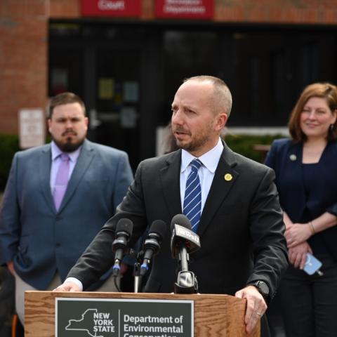 DEC Commissioner Basil Segos speaks at a lectern at a press announcement for new Climate Smart Communities