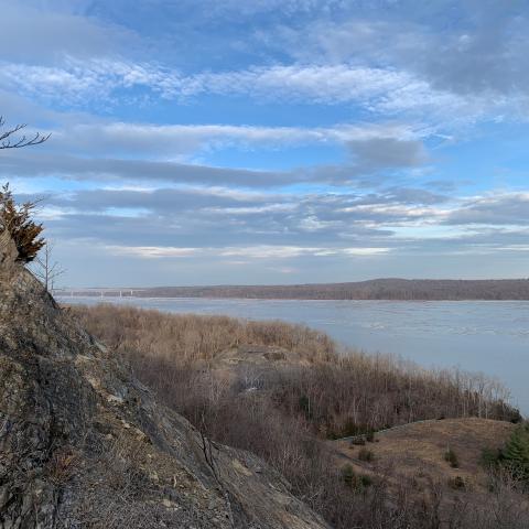 view of Hudson River from forested ledge in winter